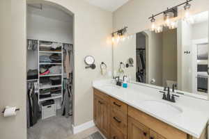 Bathroom with toilet, dual sinks, and large vanity