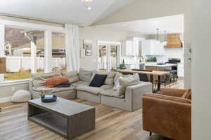 Living room featuring lofted ceiling, light hardwood / wood-style floors, and a wealth of natural light