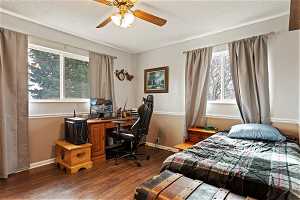 Bedroom featuring ceiling fan, a textured ceiling, and dark hardwood / wood-style flooring