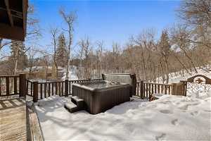 Snow covered deck featuring a hot tub