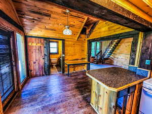 Kitchen featuring a healthy amount of sunlight, vaulted ceiling, and decorative light fixtures