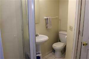 Downstairs bathroom with toilet, tile floors and shower.