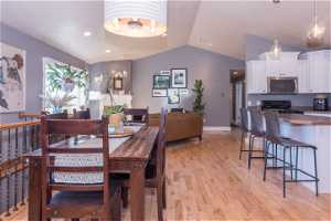 Dining room featuring vaulted ceiling and light hardwood / wood-style flooring
