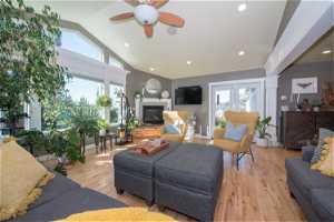 Living room featuring ceiling fan, vaulted ceiling, and light hardwood / wood-style flooring