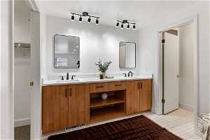 Bathroom featuring large vanity, double sink, tile floors, and track lighting