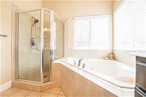 Bathroom featuring plenty of natural light, plus walk in shower, and tile floors
