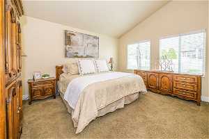 Carpeted bedroom with high vaulted ceiling