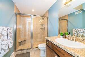 Bathroom featuring vanity, tile floors, toilet, and walk in shower