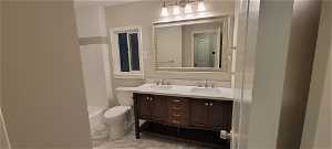 Full bathroom with tile floors, toilet, dual vanity, and bathing tub / shower combination