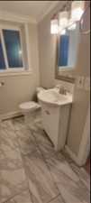 Bathroom featuring crown molding, tile floors, toilet, and vanity