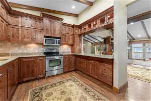 Kitchen with plenty of natural light, hardwood / wood-style floors, tasteful backsplash, and stainless steel appliances