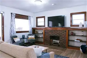 Living room featuring dark hardwood / wood-style flooring and a brick fireplace
