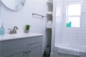Bathroom with tiled shower / bath combo and vanity