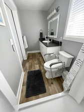 Bathroom with vanity, toilet, and hardwood / wood-style flooring