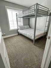 Unfurnished bedroom featuring dark carpet