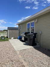 Exterior space featuring a storage unit and a patio area