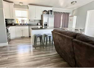 Kitchen featuring sink, white cabinets, appliances with stainless steel finishes, and light hardwood / wood-style flooring