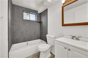 Full bathroom with toilet, vanity, and tiled shower / bath