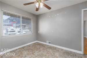 Unfurnished room with light tile floors and ceiling fan