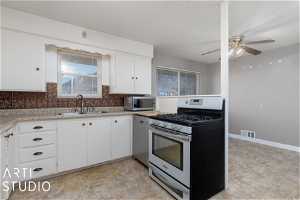 Kitchen featuring light tile flooring, ceiling fan, appliances with stainless steel finishes, and white cabinetry