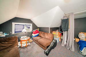 Bedroom featuring carpet floors and lofted ceiling