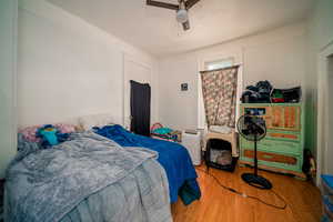 Bedroom with ceiling fan and light wood-style flooring