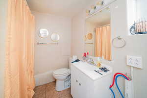 Bathroom featuring tile flooring, large vanity, and toilet