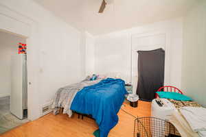 Bedroom with ceiling fan and light wood-type flooring