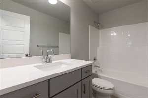 Full bathroom featuring vanity, bathtub / shower combination, and toilet