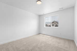 Empty room featuring light carpet