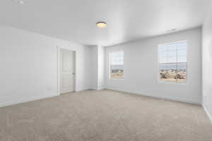 Unfurnished room with plenty of natural light and light colored carpet