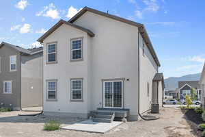 Back of property with a mountain view and cooling unit