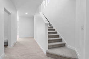 Stairs with light hardwood / wood-style flooring