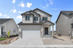 Craftsman-style house featuring cooling unit and a garage