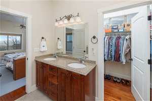 Bathroom with double vanity, ceiling fan, and hardwood / wood-style flooring
