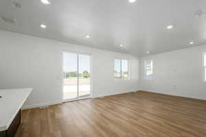 Unfurnished living room with light hardwood / wood-style floors and a textured ceiling