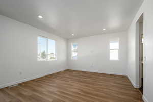 Unfurnished room featuring dark wood-type flooring and a textured ceiling