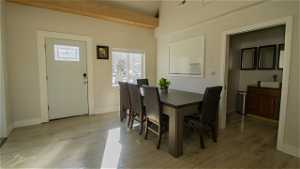 Dining space featuring laminate floors, front door and vaulted ceilings