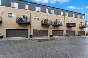 View of building exterior with a garage and central AC unit