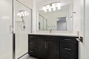 Bathroom featuring vanity and a shower with door