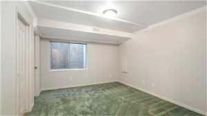 Carpeted empty room featuring crown molding