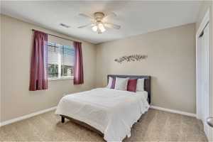 Bedroom featuring a closet, ceiling fan, and light colored carpet