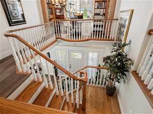 Stairway with a notable chandelier, dark hardwood / wood-style floors, and a wealth of natural light