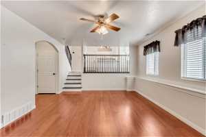 Spare room with light hardwood / wood-style floors and ceiling fan with notable chandelier