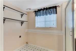 Washroom with hookup for an electric dryer and light tile floors