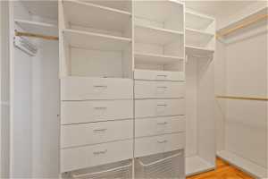 Master bedroom walk-in  closet with built in shelving and drawers.