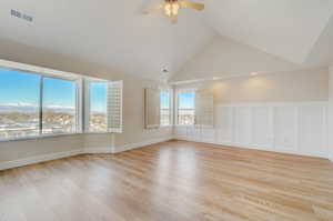 Unfurnished room with high vaulted ceiling, ceiling fan, and light wood-type flooring