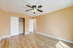 Unfurnished bedroom featuring a closet, ceiling fan, and light wood-type flooring