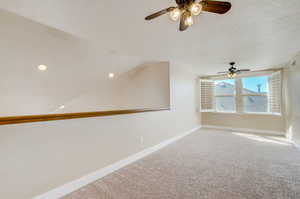 Spare room with light carpet, a textured ceiling, and ceiling fan