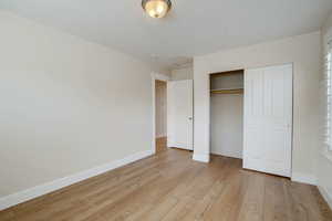 Unfurnished bedroom with a closet and light hardwood / wood-style flooring